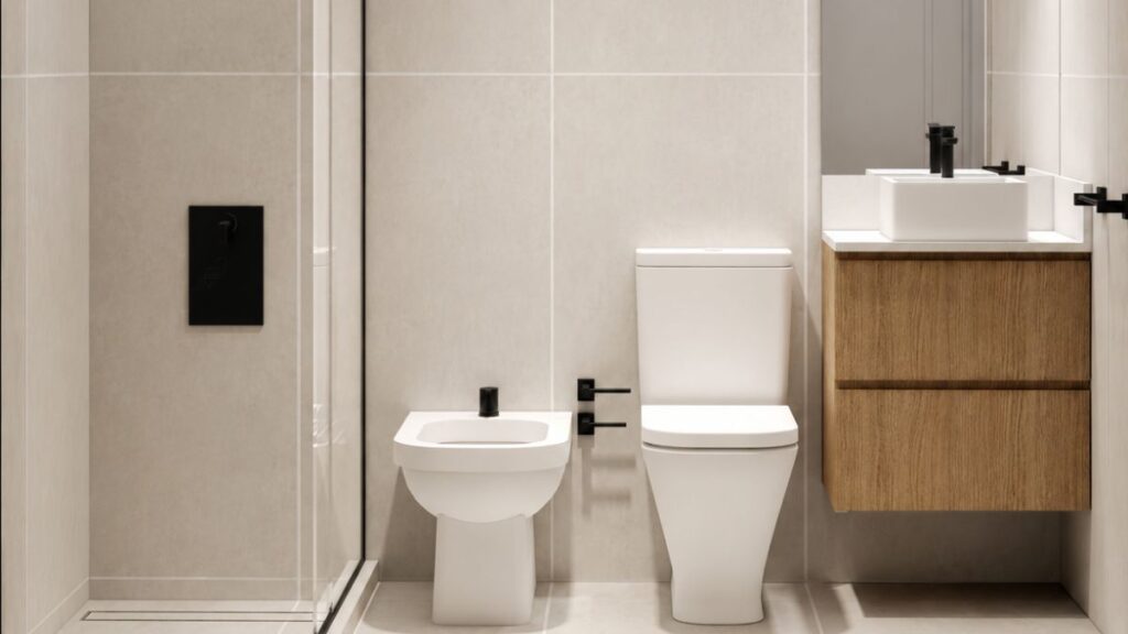 Baño pequeño remodelado con revestimientos claros, sanitarios blancos y vanitory de madera.